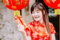 Portrait charming beautiful asian woman wear cheongsam dress gets red envelopes from her family. Pretty girl shows red envelopes.P Royalty Free Stock Photo