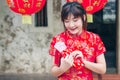 Portrait charming beautiful asian woman wear cheongsam dress up open the red envelope with money, in the Chinese New Year. Royalty Free Stock Photo