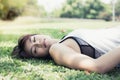 Portrait charming beautiful fainted or unconscious woman. Attractive girl is falling down on garden while she is exercising.