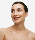 Portrait of charming, brunette woman with bare shoulders and perfect smooth skin looking away and smiling over white Royalty Free Stock Photo