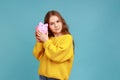 Portrait of charming curious little girl holds pig money box in hands, saving, financial or banking. Royalty Free Stock Photo