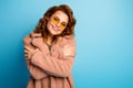 Portrait of charming cute pretty woman hug herself enjoy warm beige vogue style outercoat look good isolated over blue Royalty Free Stock Photo