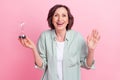 Portrait of charming funny person hold sandclock raise hand palm toothy smile isolated on pink color background