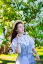 Girl in white dress near blooming apple tree Royalty Free Stock Photo