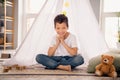 Portrait of charming happy small boy sitting floor playing smiling wear white shirt stylish child room interior Royalty Free Stock Photo