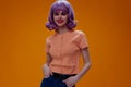 Portrait of a charming lady purple hair fashion posing glamor yellow background unaltered