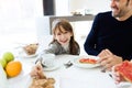 Charming little girl taking chocolate cookie and smiling at the camera on kitchen at home Royalty Free Stock Photo