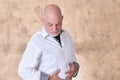 portrait of charming man in black and white shirt with gray beard and bald head feeling pain