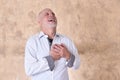 portrait of charming man in black and white shirt with gray beard and bald head feeling pain