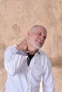 portrait of charming man in black and white shirt with gray beard and bald head feeling pain