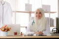 Portrait of charming muslim female doctor working at office desk and smiling Royalty Free Stock Photo