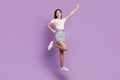 Portrait of charming sporty energetic lady jump posing hero flight on purple background