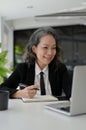 Charming Asian aged businesswoman working at her desk, using laptop computer Royalty Free Stock Photo