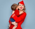 Stewardess wearing in red uniform with a child on hands