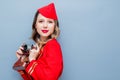 Stewardess wearing in red uniform with vintage camera