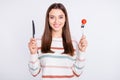 Portrait of charming woman holding tomato looking at camera with toothy smile wearing striped jumper isolated over white Royalty Free Stock Photo