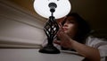 portrait of charming woman with table lamp in bedroom at night, young lady