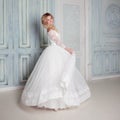 Portrait of charming woman in wedding dress. Dancing on the background walls with classic moldings Royalty Free Stock Photo