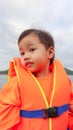 3 years old Asian little girl with orange life jacket looking up to the sky Royalty Free Stock Photo