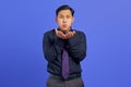 Portrait of charming young Asian man hold hand palms send air kiss on purple background Royalty Free Stock Photo