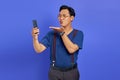 Portrait of charming young Asian man holding palms sending air kisses to smartphone while on video call Royalty Free Stock Photo