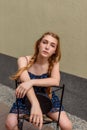 A portrait of a charming young girl with curly fair hair in a blue dress. Fashion, beauty Royalty Free Stock Photo