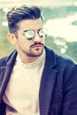 Portrait of charming young man with sunglasses outdoors