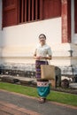 A charming young Thai-Asian woman in a traditional Thai-Northern dress is in a beautiful temple Royalty Free Stock Photo