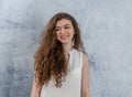 Portrait of a charming young woman. Long curly dark hair. Looks to the side. Nice smile