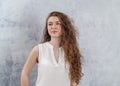 Portrait of a charming young woman. Long curly dark hair. Looks to the side. Nice smile. White blouse Royalty Free Stock Photo