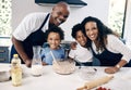 Portrait of cheerful african american family baking together at home. Happy couple and their two sons having fun while Royalty Free Stock Photo