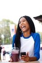 Cheerful african american girl laughing with mobile phone at cafe Royalty Free Stock Photo