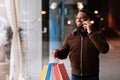 Black man talking on mobile phone holding shopping bag Royalty Free Stock Photo