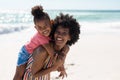 Portrait of cheerful african american mother and daughter enjoying at beach on sunny day Royalty Free Stock Photo