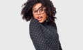 Portrait of cheerful African American woman smiling and spinning with her healthy hair, feeling happy, posing over white wall.