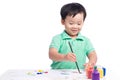 Portrait of cheerful asian boy painting using watercolors