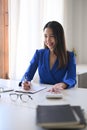 Cheerful asian business woman working in bright office. Royalty Free Stock Photo