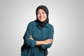 Portrait of cheerful Asian muslim woman with hijab, keeping arms crossed and smiling looking at camera. Isolated image on white Royalty Free Stock Photo