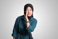 Portrait of cheerful Asian woman with hijab, trying to hear gossip or sound, holding hand near ear and listening carefully. Royalty Free Stock Photo