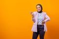 Portrait of cheerful attractive asian woman pointing finger at empty space