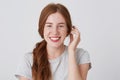 Portrait of cheerful attractive young woman with red hair and freckles feels happy and smiling isolated over white background Royalty Free Stock Photo