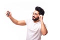 Portrait of a cheerful bearded arab man taking selfie over white background Royalty Free Stock Photo