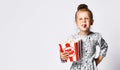 Portrait of a cheery pretty girl holding plastic cup and eating popcorn isolated over white background Royalty Free Stock Photo