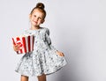 Portrait of a cheery pretty girl holding plastic cup and eating popcorn isolated over white background Royalty Free Stock Photo