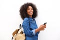 Cheerful black woman with backpack holding mobile phone Royalty Free Stock Photo