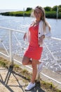 Portrait of cheerful blond young woman on river beach coast