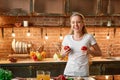 Good food choices are good investments. Happy young woman cooking vegetables in modern kitchen. Cozy interior Royalty Free Stock Photo