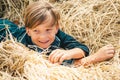 Portrait of a cheerful boy lying in a hay. Autumn dream. Kid dreams on autumn nature. Childhood dream concept