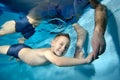 Portrait of a cheerful boy underwater with his father& x27;s hands lowered into the water. He holds hands and smiles. Active Royalty Free Stock Photo