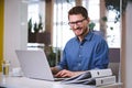 Portrait of cheerful businessman working on laptop at creative office Royalty Free Stock Photo